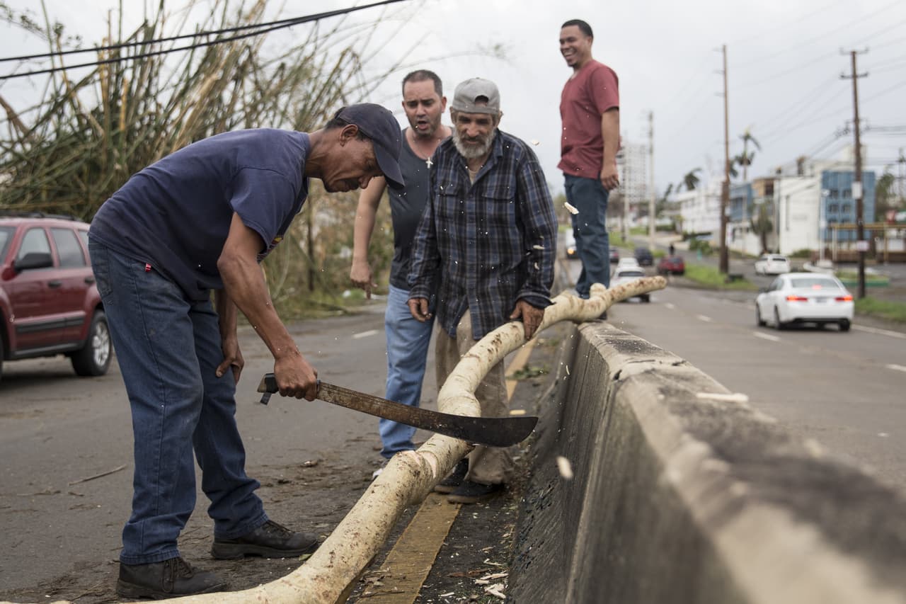 SAN JUAN, PUERTO RICO - SEPTEMBER 21: Residents clear the highway to make room for traffic in San Juan after Hurricane Maria made landfall, September 21, 2017 in San Juan, Puerto Rico. The majority of the island has lost power, in San Juan many are left without running water or cell phone service, and the Governor said Maria is the "most devastating storm to hit the island this century." (Photo by Alex Wroblewski/Getty Images)