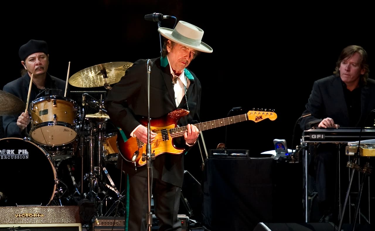 Para conmemorar los 50 años sobre el escenario, Bob Dylan afianzando su estilo de sombrero de copa y smoking de colores vibrantes que lo ha caracterizado en su faceta más amdura, se embarcó en un tour que lo llevó por todo el mundo. Llegó hasta Shangai, China, un lugar en donde sus canciones de protesta e indignación tuvieron mucha resistencia para entrar. PHILIPPE LOPEZ/AFP/Getty Images