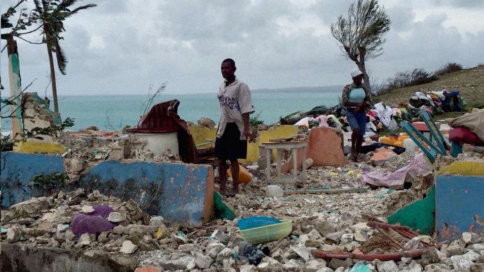 A man and a woman pick through rubble of a home in Ile-a-Vache after the passage of Hurricane Matthew. The island of 10,000 people suffered massive damage to homes.