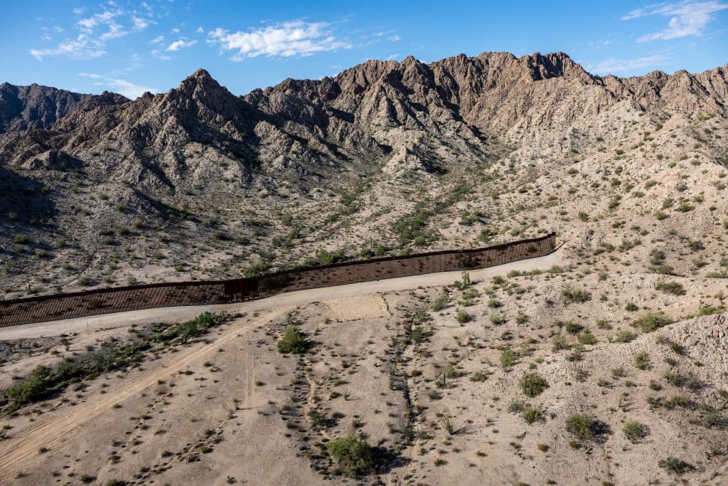 As seen from a U.S. Customs and Border Protection (CBP) helicopter patrol, the U.S.-Mexico border fence stops at a mountainside on September 28, 2022 near Welton, Arizona.