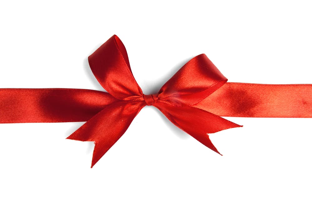 Envuelve la vela con el pergamino y átalo con la cinta roja.