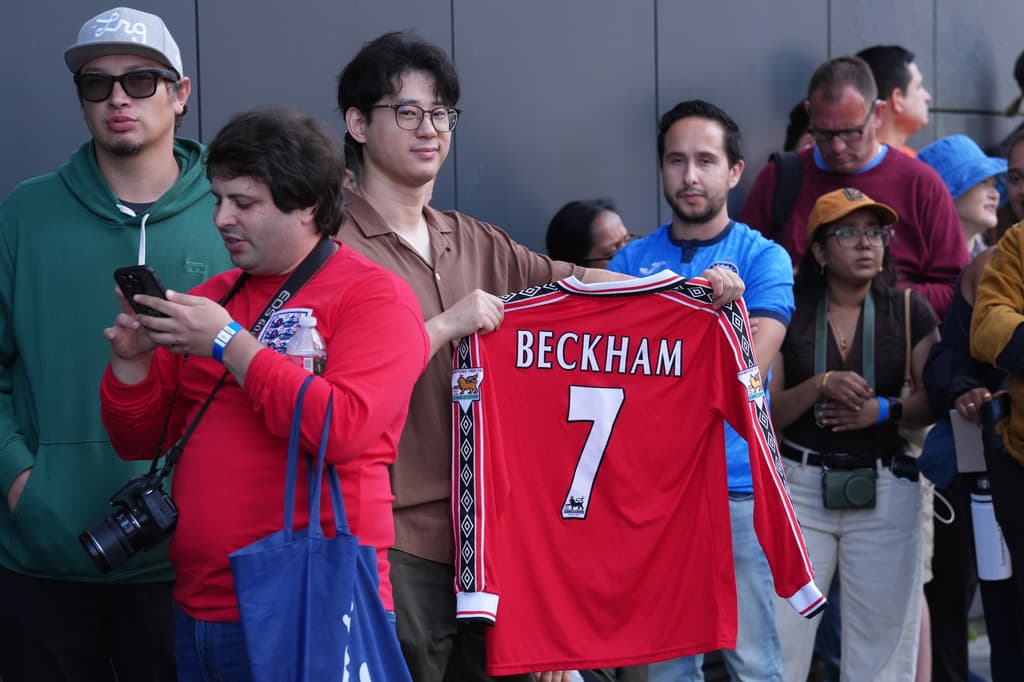El entorno del homenaje reflejó el interés del público: asistentes levantaron recuerdos y prendas relacionadas con el exfutbolista mientras esperaban la sesión principal de fotografías. En la foto: Nathan Chen sostuvo una camiseta de David Beckham.