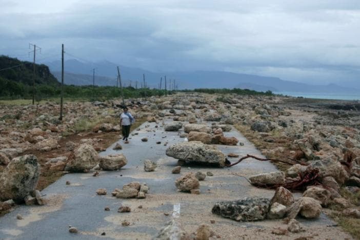 A woman walks on a highway blocked by rocks after the passage of hurricane Matthew on the coast of Guantanamo province, Cuba, October 5, 2016.