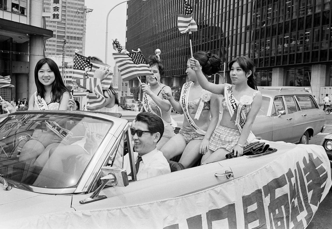 Ciudadanos celebran el alunizaje exitoso del Apolo 11 frente a la Embajada de Estados Unidos en Tokio, con la bandera estadounidense; el 21 de julio de 1969 (AP Photo)