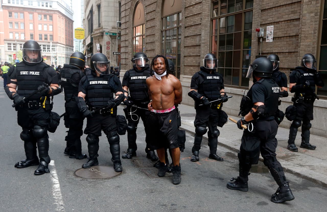 Police escort a counter-protester. Initial estimates indicate that about 15,000 people participated in the anti-hate demonstration.