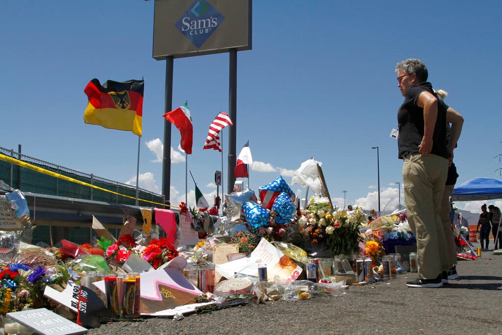 In this Aug. 12, 2019 photo, mourners visit the makeshift memorial near the Walmart in El Paso, Texas, where 22 people were killed in a mass shooting that police are investigating as a terrorist attack targeting Latinos.